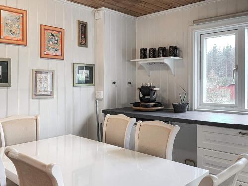 a kitchen with a white table and chairs at 10 person holiday home in VITTSJÖ in Vittsjö