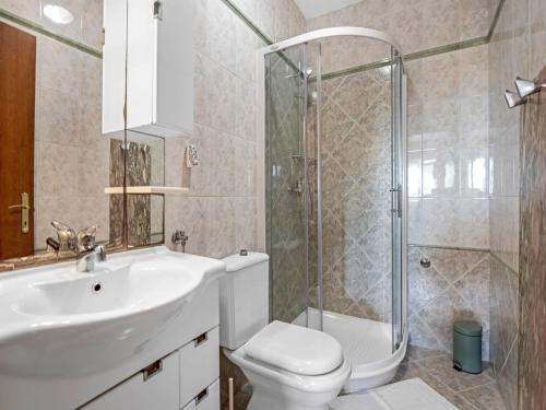 a bathroom with a toilet and a sink and a shower at Apartment near Rab Beach in Banjol