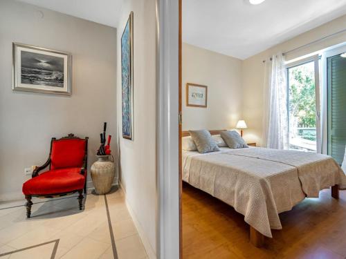 a bedroom with a bed and a red chair at Apartment near Rab Beach in Banjol