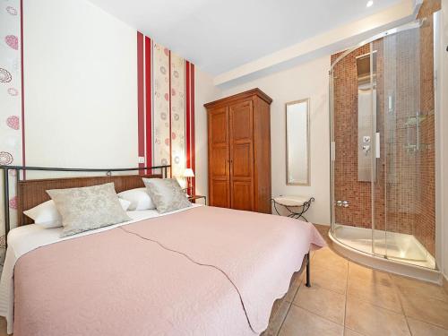 a bedroom with a bed and a glass shower at Serene Studio by the Sea in Banjol