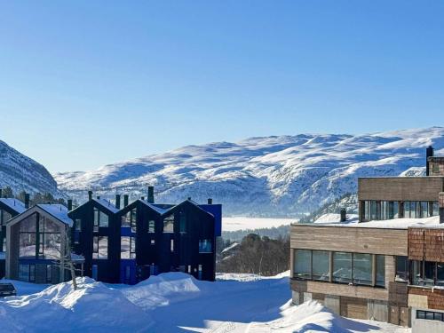 a building in the snow with mountains in the background at 4 star holiday home in HOVDEN in Hovden