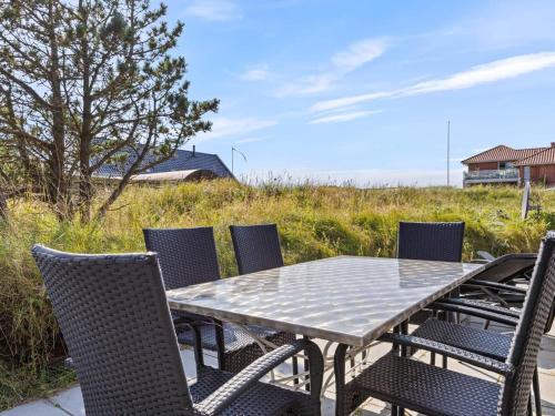 a table and chairs on a patio with a field at 4 star holiday home in Nørre Nebel in Nørre Nebel