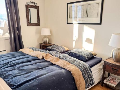 a bed with blue sheets on it in a bedroom at 4 star holiday home in HOVDEN in Hovden