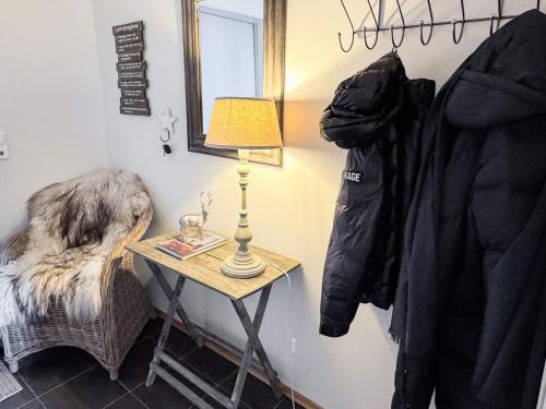 a small table with a lamp and a chair in a room at 4 star holiday home in HOVDEN in Hovden