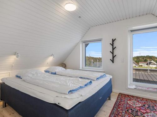two beds in a white room with a window at 4 star holiday home in Nørre Nebel in Nørre Nebel