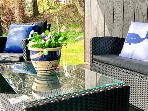 a vase with flowers on a glass table on a patio at 7 person holiday home in Molde in Molde