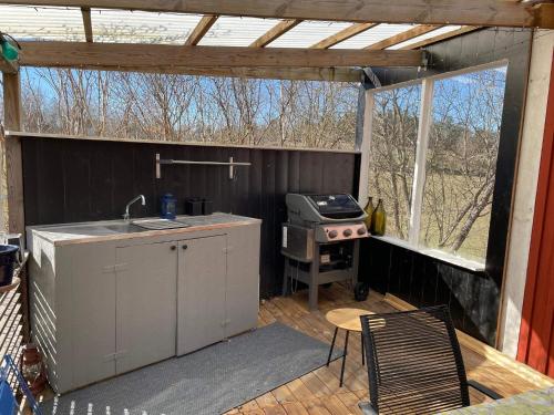 a screened in patio with a grill and a stove at 6 person holiday home in VIMMERBY in Vimmerby