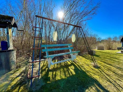 a blue bench sitting in a park with a light at 6 person holiday home in VIMMERBY in Vimmerby