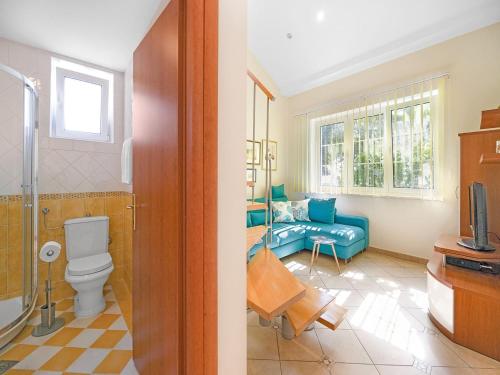 a bathroom with a toilet and a couch in a room at Apartment with Garden, Banjol in Banjol