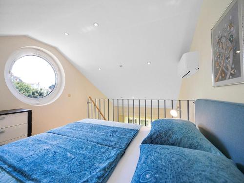 a bedroom with a bed with blue sheets and a window at Apartment with Garden, Banjol in Banjol