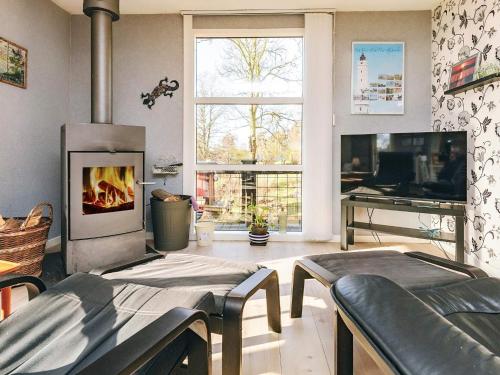 a living room with a fireplace and a tv at 4 person holiday home in Vordingborg in Vordingborg