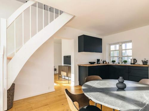 a kitchen and dining room with a table and a staircase at 5 star holiday home in Liseleje in Liseleje