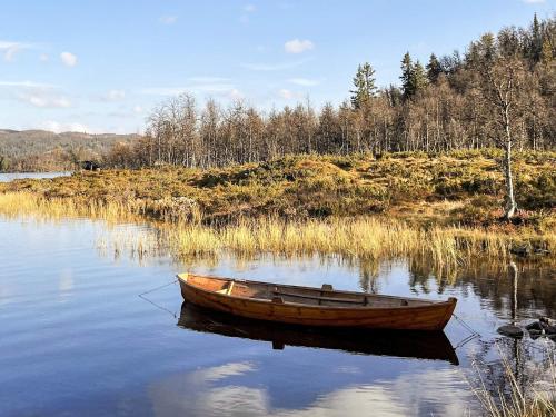 a wooden boat sitting in the middle of a lake at 4 star holiday home in gol in Gol