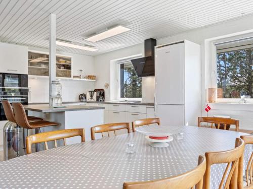 a kitchen with a table and chairs in a kitchen at 4 star holiday home in Nørre Nebel in Nørre Nebel