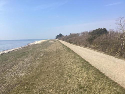 a dirt road next to the ocean at 6 person holiday home in Dannemare in Dannemare