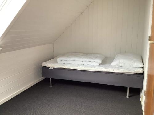 a bed in a small room with two pillows on it at 5 person holiday home in Snedsted in Snedsted