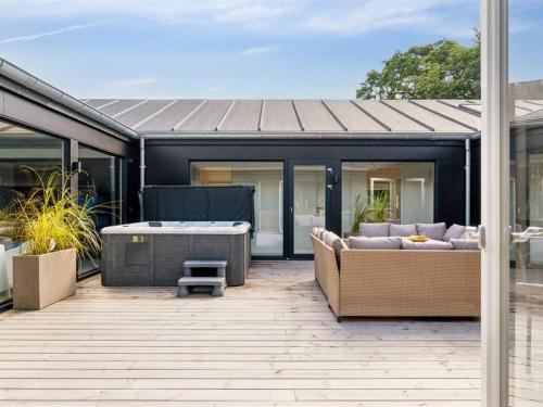 a patio with two couches and a hot tub at 5 star holiday home in Glesborg in Glesborg