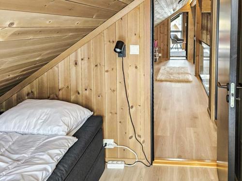 ein Bett in einem Zimmer mit einer Holzwand in der Unterkunft 11 person holiday home in Hornnes in Hornnes