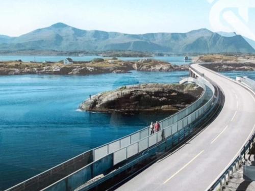 a highway next to a body of water with mountains at 7 person holiday home in Molde in Molde