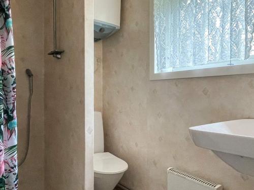 a bathroom with a toilet and a sink and a window at 4 person holiday home in KÖPINGSVIK in Köpingsvik
