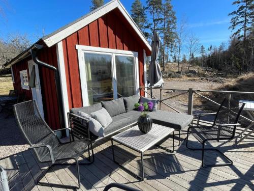 a patio with a couch and chairs and a table at 6 person holiday home in VIMMERBY in Vimmerby