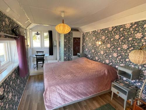 a bedroom with a bed and floral wallpaper at 6 person holiday home in VIMMERBY in Vimmerby