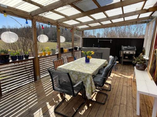 a patio with a table and chairs on a deck at 6 person holiday home in VIMMERBY in Vimmerby
