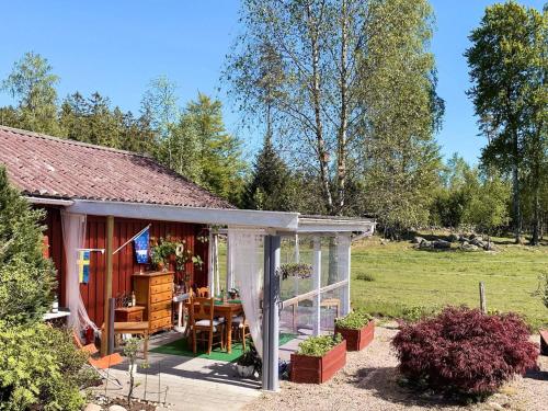 a red cottage with a table and chairs in a yard at 10 person holiday home in VITTSJÖ in Vittsjö