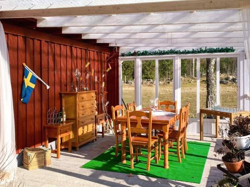 a dining room with a table and chairs on a patio at 10 person holiday home in VITTSJÖ in Vittsjö