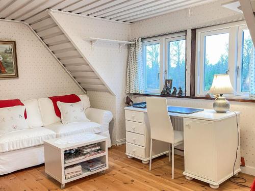 a living room with a couch and a desk at 10 person holiday home in VITTSJÖ in Vittsjö