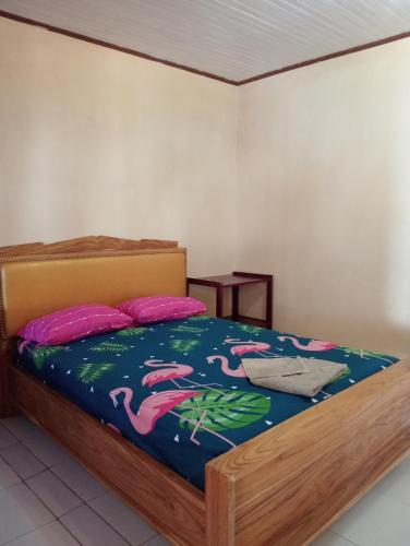 a bedroom with a bed with pink flamingos on it at MAMALIS HOMESTAY in Manado
