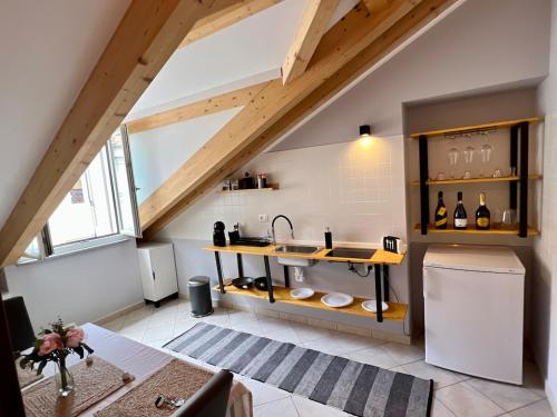an attic kitchen with a sink and a refrigerator at Jacuzzi Turin Center - Serendipity Suite in Turin