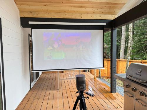 a large screen on a screened porch with a projector at Glacier Run, Hot Tub, Sauna,Movie Theater, WiFi, EV in Ashford