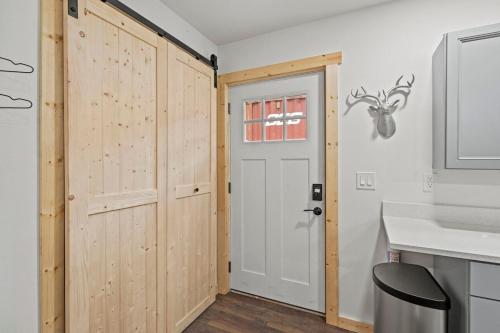 a bathroom with a wooden door and a sink at Glacier Run, Hot Tub, Sauna,Movie Theater, WiFi, EV in Ashford