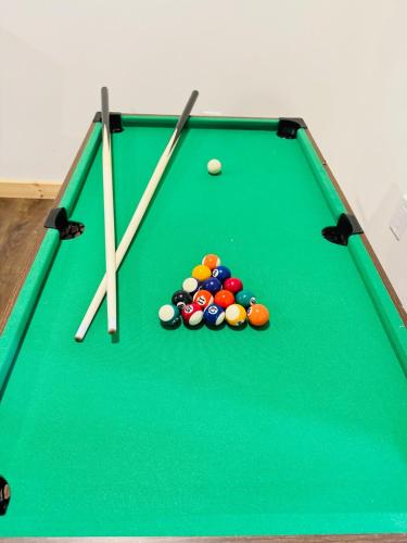 a green felt pool table with balls and cues at Glacier Run, Hot Tub, Sauna,Movie Theater, WiFi, EV in Ashford