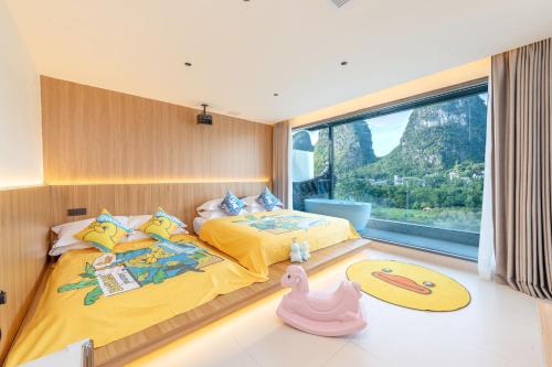 two beds in a room with a large window at Yangshuo Hidden Dragon Villa in Yangshuo