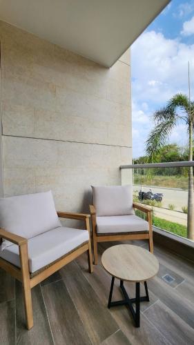 two chairs and a coffee table on a balcony at Con jacuzzi privado, laguna y Paddle board in Cartagena de Indias