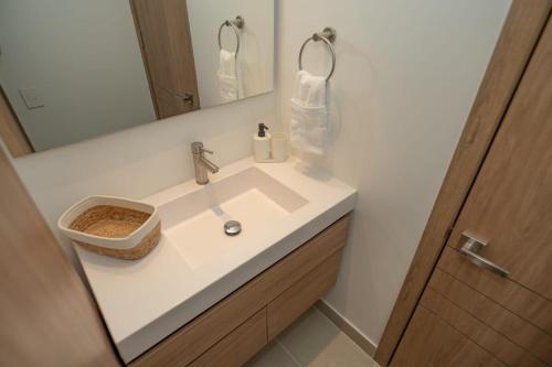 a bathroom with a white sink and a mirror at Con jacuzzi privado, laguna y Paddle board in Cartagena de Indias