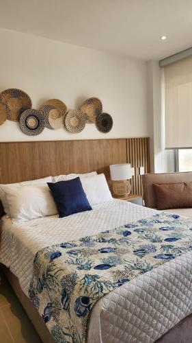a bedroom with a bed with a blue and white comforter at Con jacuzzi privado, laguna y Paddle board in Cartagena de Indias