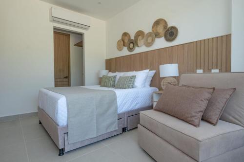 a white bedroom with a bed and a couch at Con jacuzzi privado, laguna y Paddle board in Cartagena de Indias