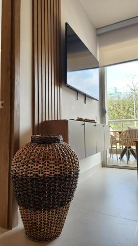 a living room with a large wicker vase on the floor at Con jacuzzi privado, laguna y Paddle board in Cartagena de Indias