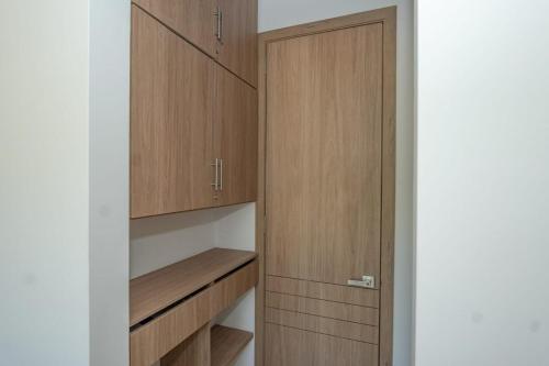 a walk in closet with wooden cabinets at Con jacuzzi privado, laguna y Paddle board in Cartagena de Indias