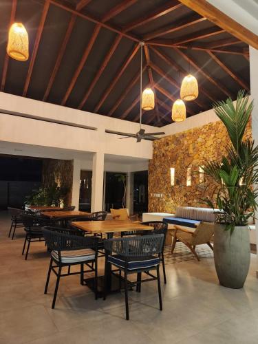 a restaurant with tables and chairs and a stone wall at Con jacuzzi privado, laguna y Paddle board in Cartagena de Indias
