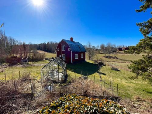 a red barn in the middle of a field at 6 person holiday home in VIMMERBY in Vimmerby