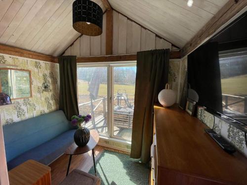a living room with a blue couch and a window at 6 person holiday home in VIMMERBY in Vimmerby