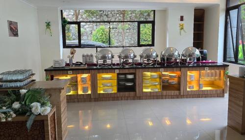 a kitchen with a counter with yellow dishes at Point C Hotel in Bandung