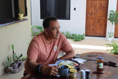 a man sitting at a table with a plate of food at Hotel Huacas in Huacas