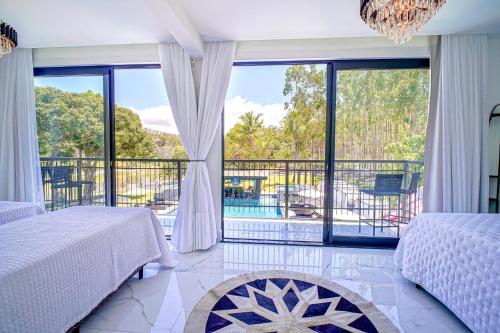 a bedroom with two beds and a balcony at Fletcher American Manor Hotel & Resort in Prado
