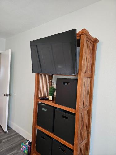 a tv on top of a wooden book shelf at Comfort Location Reasonable Price 2 blocks 2 the beach in Kailua-Kona