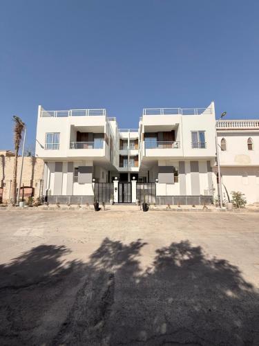 a large white building in front of a parking lot at Bohemia palace in Hurghada